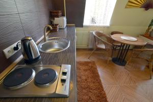 cocina con tetera y fregadero en Dragomir Apartments, en Cherkasy