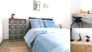 - une chambre avec un lit bleu et un bureau dans l'établissement L'arsenal * Vue Pyrénées * tout Confort, à Tarbes