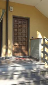 a wooden door on a building with a fence at Casa con giardino vicino al mare in Massa