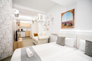 a white bedroom with a bed and a kitchen at dobohomes - Horcajuelo in Madrid