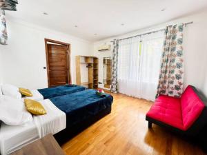 a bedroom with a bed and a red chair at Villa Pereybère White Pearl in Pereybere