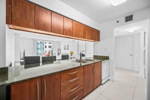 a kitchen with wooden cabinets and a counter top at Luxurious 1 Bed Apartment in Brickell • Ocean View in Miami