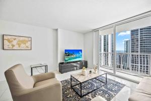 a living room with a couch and a tv at Luxurious 1 Bed Apartment in Brickell • Ocean View in Miami