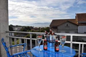 - une table avec des verres et des bouteilles de bière sur le balcon dans l'établissement Apartamento Corcubica mirando al mar, à Vilagarcía de Arousa