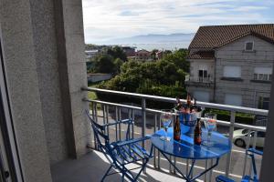 - une table et des chaises sur un balcon avec des verres à vin dans l'établissement Apartamento Corcubica mirando al mar, à Vilagarcía de Arousa