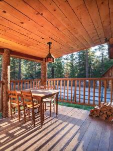 - une terrasse couverte en bois avec une table et des chaises dans l'établissement Corkins Lodge, à Chama
