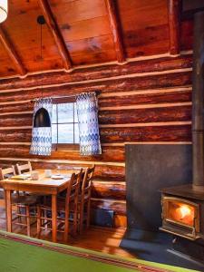 une salle à manger avec une table, des chaises et une cheminée dans l'établissement Corkins Lodge, à Chama