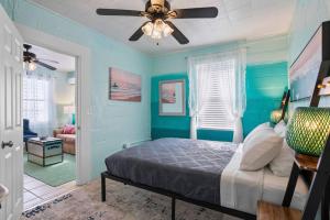 1 dormitorio con paredes azules y 1 cama con ventilador de techo. en Mermaids Grotto WATERFRONT 1BR Apt with Bay View, en Tampa