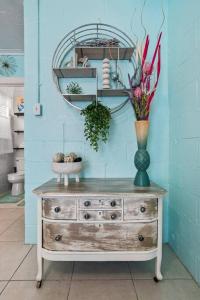 a dresser with a vase of flowers and a mirror at Mermaids Grotto WATERFRONT 1BR Apt with Bay View in Tampa