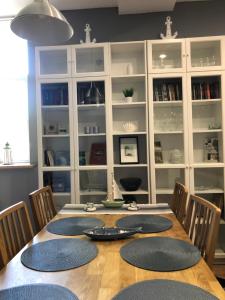 uma sala de jantar com uma mesa com cadeiras e pratos em Apartment Windau em Ventspils