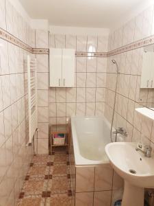een badkamer met een wit bad en een wastafel bij Central Apartment Bucharest Mall in Vitan
