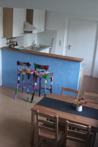 een keuken met 2 stoelen, een tafel en een aanrecht bij Ferienwohnung Freiburg Herdern in Freiburg im Breisgau