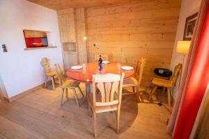 a wooden dining room with a table and chairs at Chantemerle 6 in Méribel