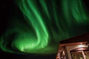 an image of the northern lights in the sky at ÁLka - Cozy Room by the Sea With Private Hot Tub in Njarðvík