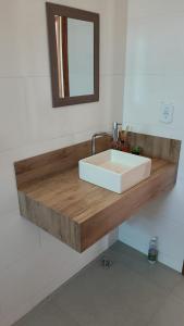 a bathroom with a white sink and a mirror at RANCHO PARAISO Do ZIRINHO in Guapé