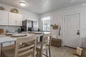 a kitchen with white cabinets and a table with chairs at The Sea House WATERFRONT Apt by Downtown in Tampa