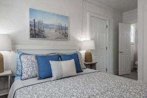 a bedroom with a bed with blue and white pillows at The Sea House WATERFRONT Apt by Downtown in Tampa