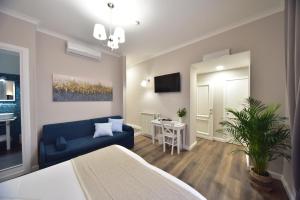 ein Wohnzimmer mit einem blauen Sofa und einem Tisch in der Unterkunft Sacconi Palace Suite Roma in Rom