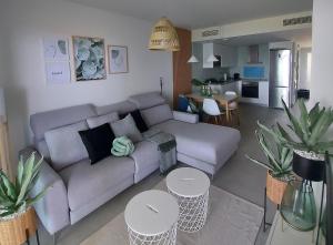 sala de estar con sofá, mesas y cocina en Blue Sunset Luxury Seaview Apartment La Duquesa, en Manilva