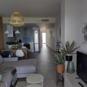 a living room with a couch and a kitchen at Blue Sunset Luxury Seaview Apartment La Duquesa in Manilva