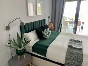 a bedroom with a large bed with a green headboard at Blue Sunset Luxury Seaview Apartment La Duquesa in Manilva +34 photos