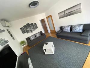 a living room with two couches and a table at Apartman Sweet Garden K&A in Zagreb