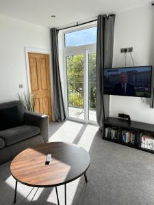 a living room with a coffee table and a tv at Beautiful 2 bedroom with patio and amazing views in Hebden Bridge