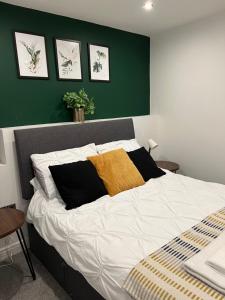 1 dormitorio con 1 cama grande y pared verde en Beautiful 2 bedroom with patio and amazing views, en Hebden Bridge