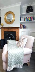 a living room with a chair and a mirror at Windsor Cottage: Cosy, Charming, Full of Character in Windsor