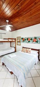 Ce lit se trouve dans un dortoir doté d'un plafond en bois. dans l'établissement Pousada Mandala, à Búzios