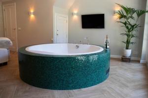 Ett badrum på Guesthouse "Mirabelle" met indoor jacuzzi, sauna & airco
