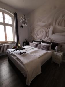 a bedroom with a large white bed with a chandelier at Pension Zur Alten Post in Havelberg