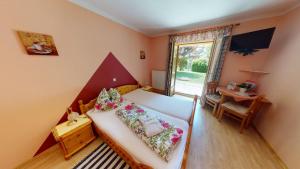 1 dormitorio con cama, mesa y ventana en Pension Thermensonne, en Jennersdorf