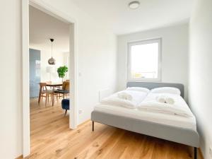 a white bedroom with a bed and a dining room at STAD10 - Apartments very close to subway U2 Stadlau in Vienna
