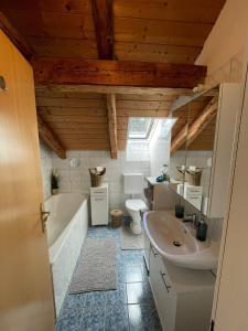 a bathroom with a tub and a toilet and a sink at BullsLiving Seeapartment 2 AM CORSO in Velden am Wörthersee