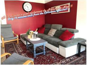 ein Wohnzimmer mit einem Sofa und einer Uhr an der Wand in der Unterkunft BedinReims "burgundy bottle" 110m2 Exceptional, 4 chambres doubles, 2 bain, free park & wifi, tout équipé in Reims