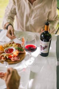 una persona sentada en una mesa con una copa de vino en Agriturismo Albafiorita en Latisana