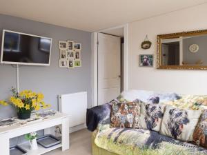 a living room with a couch and a tv at Bumbles Barn in Slamannan