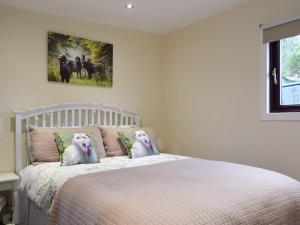 two white dogs sitting on a bed in a bedroom at Bumbles Barn in Slamannan