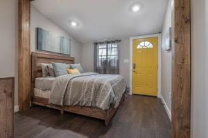 a bedroom with a bed and a yellow door at Gambino Getaway Shotgun style apt in the heart of Ybor City in Tampa