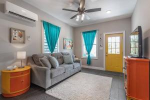 a living room with a couch and a ceiling fan at Franks Farmhouse Shotgun style apt in Ybor City in Tampa
