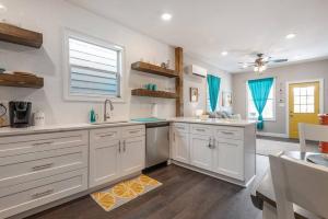 a large kitchen with white cabinets and a window at Franks Farmhouse Shotgun style apt in Ybor City in Tampa
