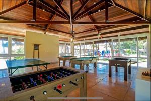 una habitación con mesas de ping pong y pelotas de ping pong en Flat no Hotel Jatiúca suítes resort en Maceió