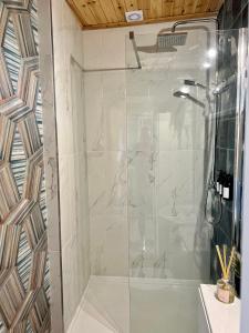 a shower with a glass door in a bathroom at The Stables Hideaway in Llanelli