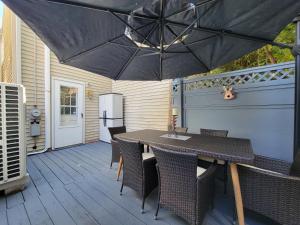 eine Terrasse mit einem Tisch, Stühlen und einem Sonnenschirm in der Unterkunft The Iris - A Cheerful Midtown Getaway in Harrisburg