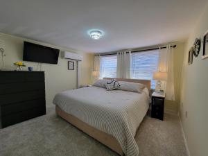 a bedroom with a bed and a television in it at The Iris - A Cheerful Midtown Getaway in Harrisburg