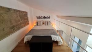 um quarto com uma cama num quarto branco em KirasHouse no Porto