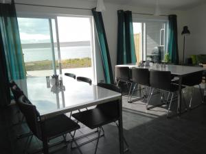 a dining room with a table and chairs and a view of the ocean at Guesthouse 46 in Hvammstangi