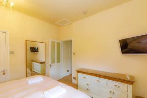 a bedroom with a bed and a tv on the wall at Park Crescent apartment in York