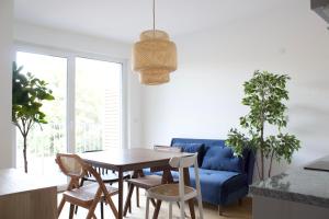 a living room with a table and a blue couch at STAD10 - Apartments very close to subway U2 Stadlau in Vienna